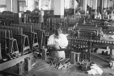 Black and white photo of a worker in a remington factory