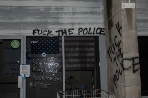 Graffiti on CEL office Building facade with  etched glass sign reading "Stop Cop City". Graffiti reading "Fuck the Police" on CEL office  in Windsor CA