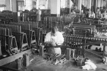 Black and white photo of a worker in a remington factory