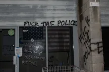 Building facade with  etched glass sign reading "Stop Cop City". Graffiti reading "Fuck the Police" on CEL office  in Windsor CA